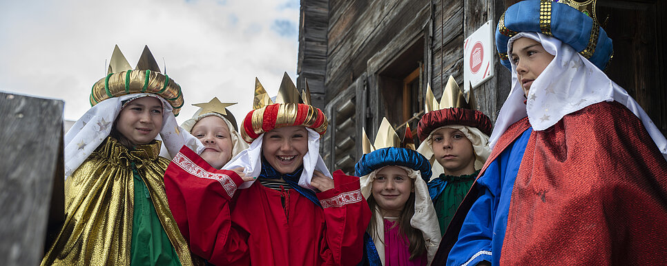 Sternsingerkinder lachen zusammen und stehen im Kreis.
